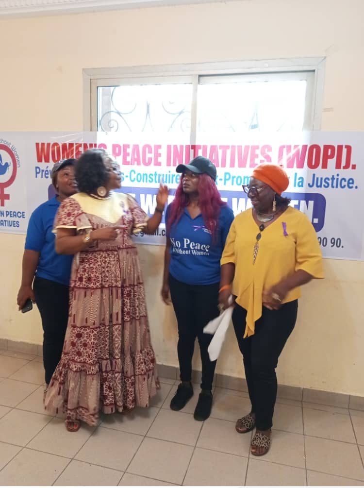 Des membres de WOPI et de l'ACMA devant la banderole de WOPI